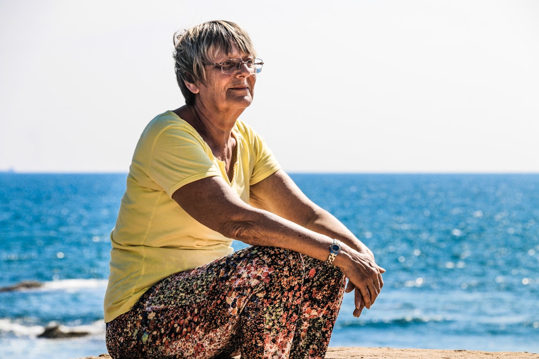 A woman sitting peacefully by the seashore, feeling calm and relieved